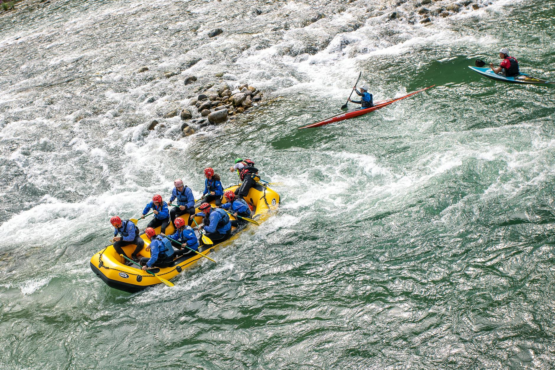 Group guided river rafting through whitewater rapids