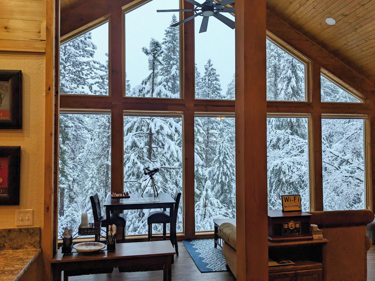 Interior with cathedral windows looking out onto snow-covered forest